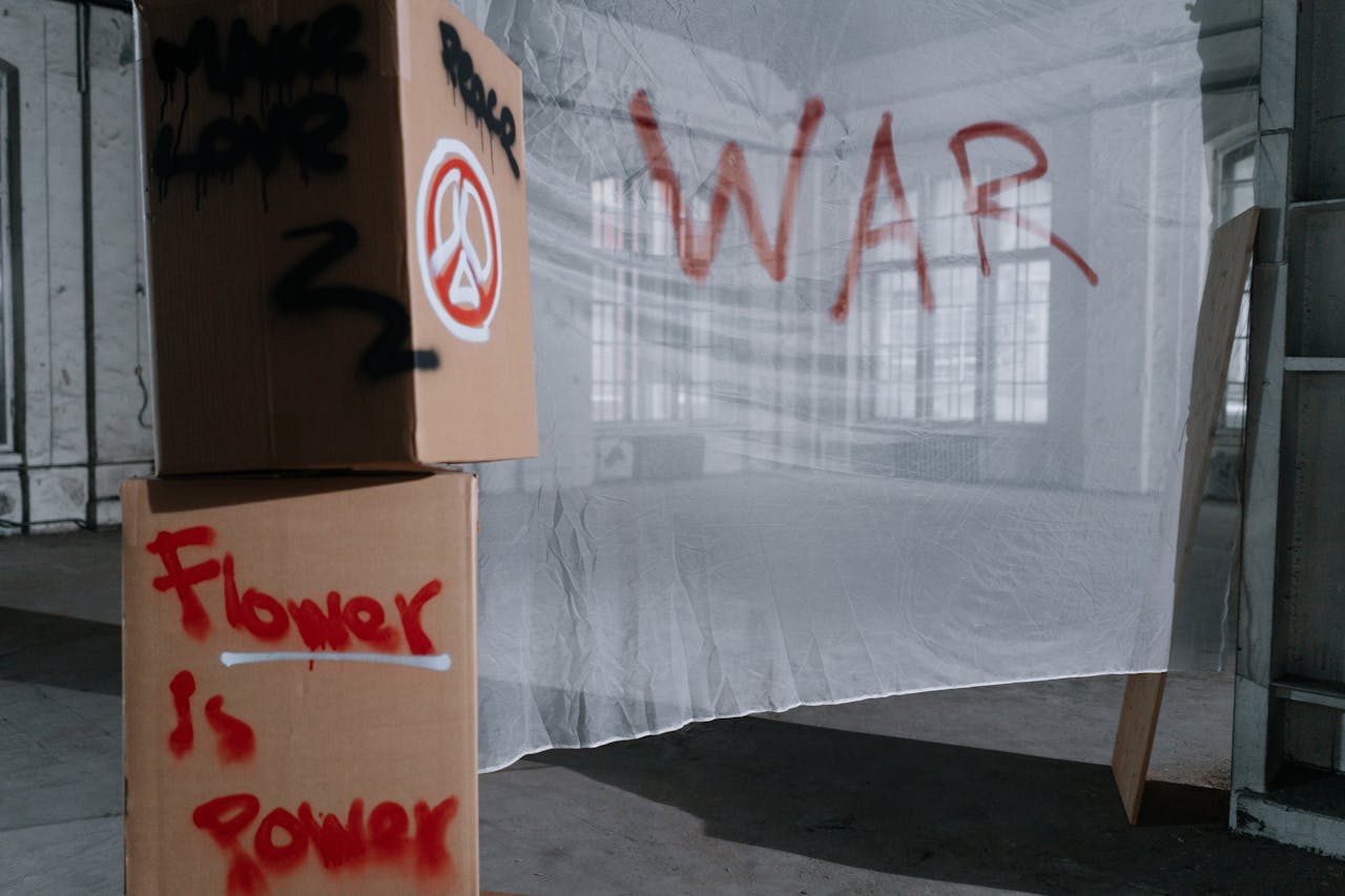 Cardboard boxes with peace and anti-war slogans in a protest setting.